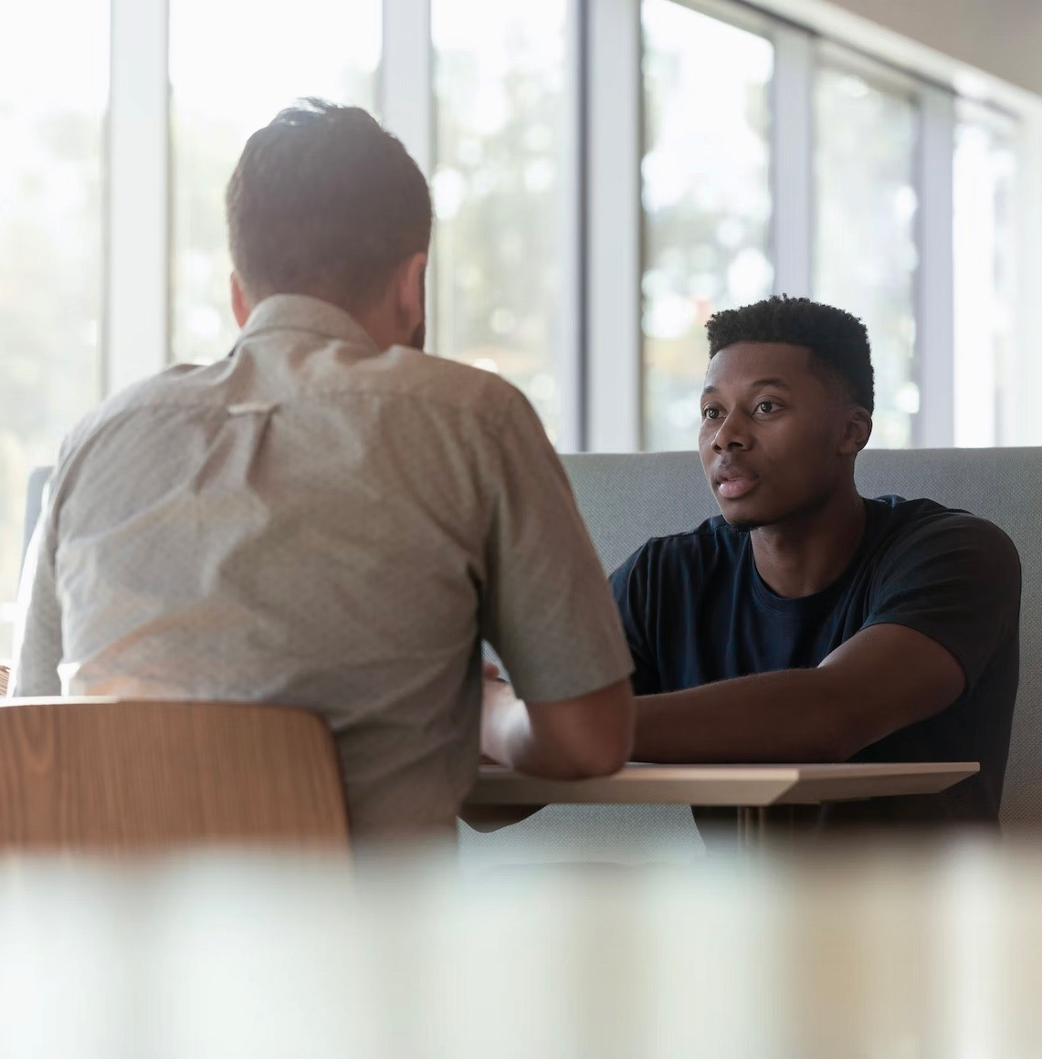 Two men sitting at a table having a conversation